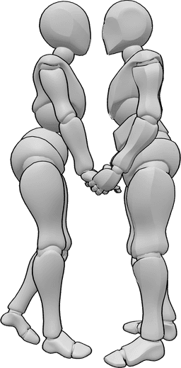 Posen-Referenz- Romantische Pose des Händchenhaltens - Eine Frau und ein Mann stehen voreinander, halten sich an den Händen und sind dabei, sich zu küssen.