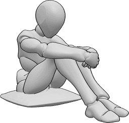 Référence des poses- Femme assise tristement - La femme est assise tristement sur un oreiller, serrant ses genoux et regardant vers le bas.